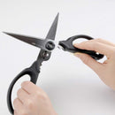 Hands using OXO Good Grips kitchen shears for precision cutting