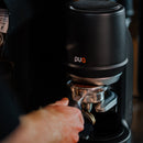 Person using a black puqpress pro with 'PUQ' branding.
