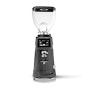 A professional electric coffee grinder with a dark gray body, clear hopper, and digital touch screen interface, shown on a solid white background.