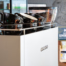White Ascaso Barista T One espresso machine with chrome cup warmer and black ceramic cups