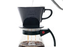 Coffee dripping from Kalita 102 ceramic dripper into glass server