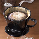 Blooming coffee grounds in Kalita 102 ceramic dripper during pour-over brewing