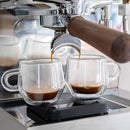 Double shot espresso extraction from Ascaso Steel DUO into double-walled glass cups with light crema