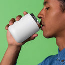 Man sipping from white Fellow Carter Wide insulated stainless steel travel mug