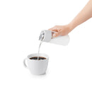 Pouring milk from OXO creamer into coffee cup