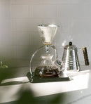 Lifestyle shot of Yama Glass Silverton Brewer brewing coffee next to gooseneck kettle